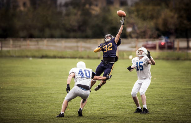 Football player leaping to catch a pass during a game
