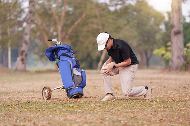 Golfer kneeling on the course and holding his knee in pain