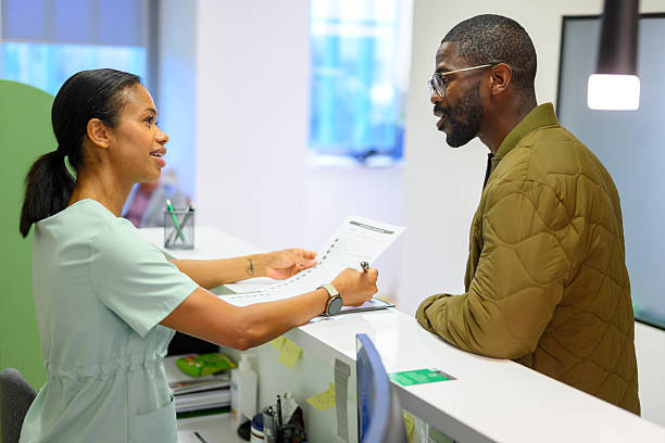 Clinic receptionist welcoming a patient at the front desk
