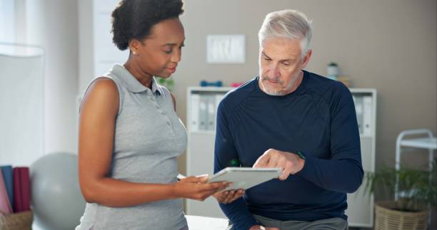 Physical therapist reviewing an exercise plan with a patient on a tablet