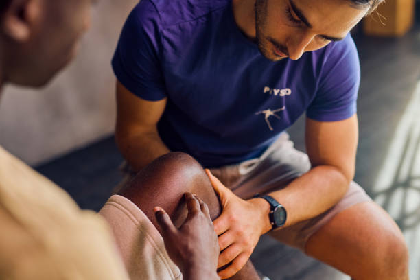 Physical therapist examining a patient's knee in a rehabilitation clinic