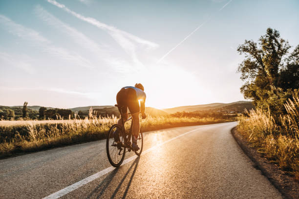 Road cyclist on a training ride at sunset