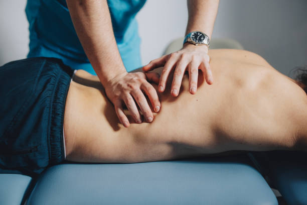 Close-up of a physical therapist treating a patient's lower back