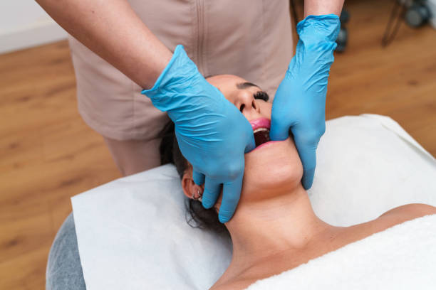 Therapist administering manual TMJ therapy for jaw pain