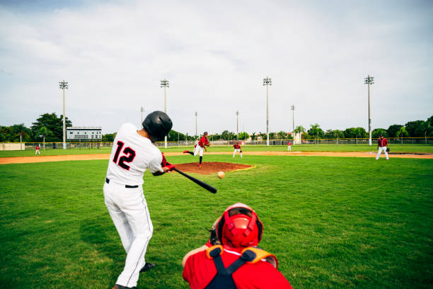 Teen baseball player swinging his bat at a thrown pitch during a game
